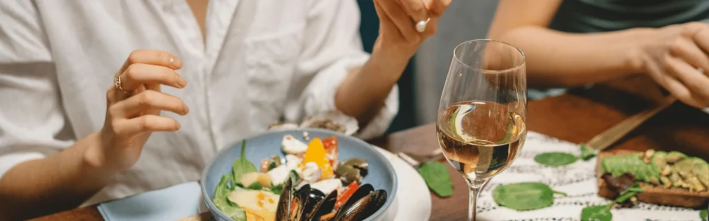 A woman eating avocado in a restaurant - goof fat in WFPB.