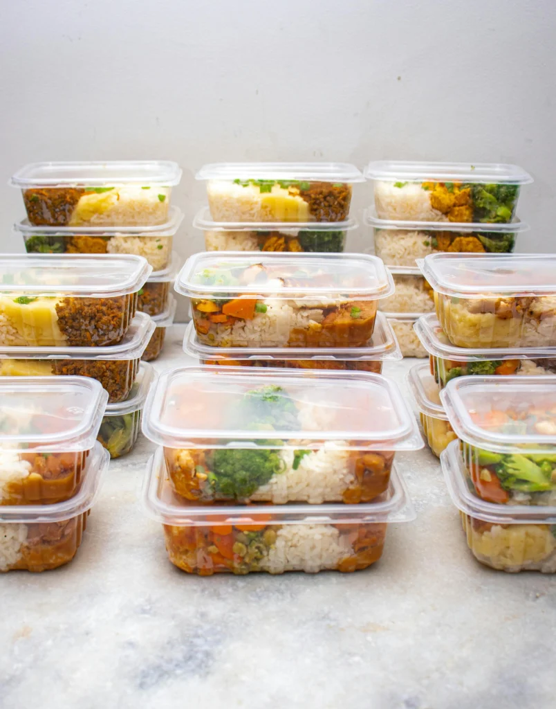 Healthy meal prep containers with rice and vegetables for easy plant-based diet plan.