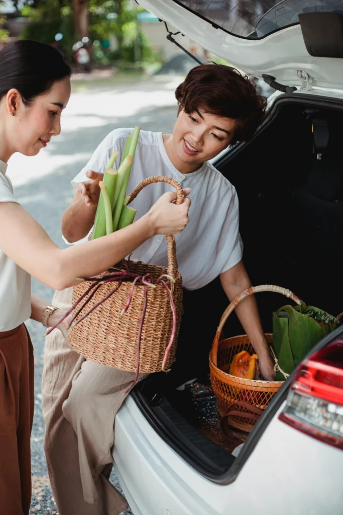 Asian girlfriends putting baskets in a trunk