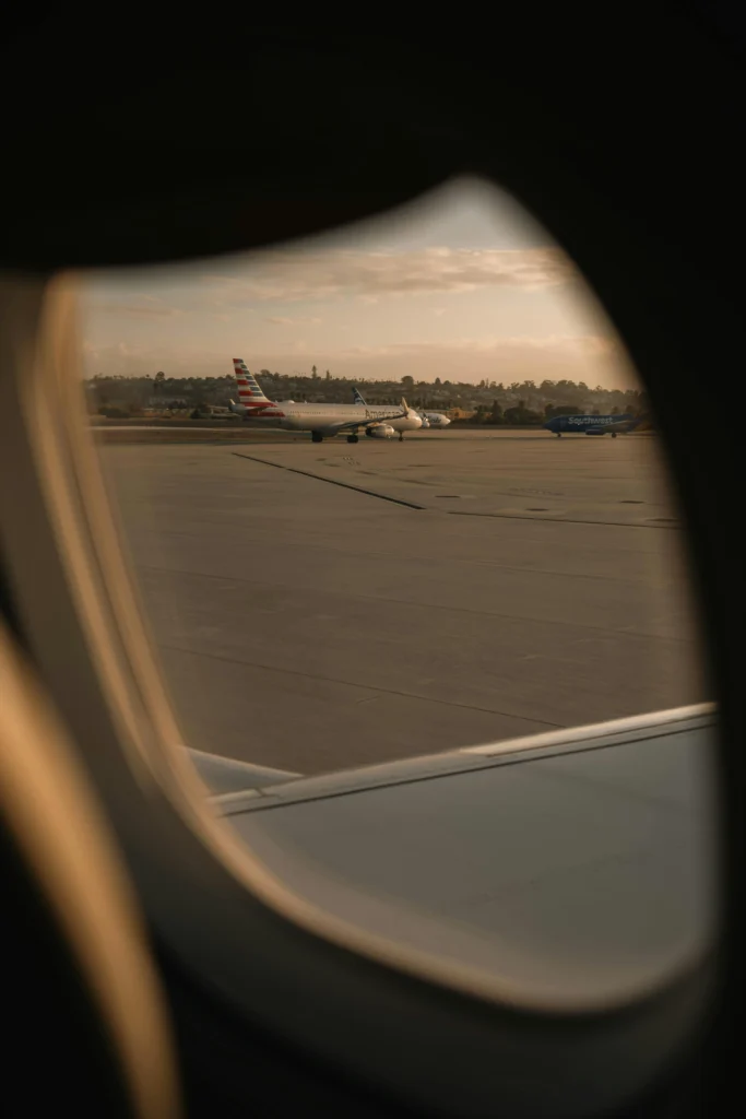 Airplane view from window at sunset on airport runway for travel.