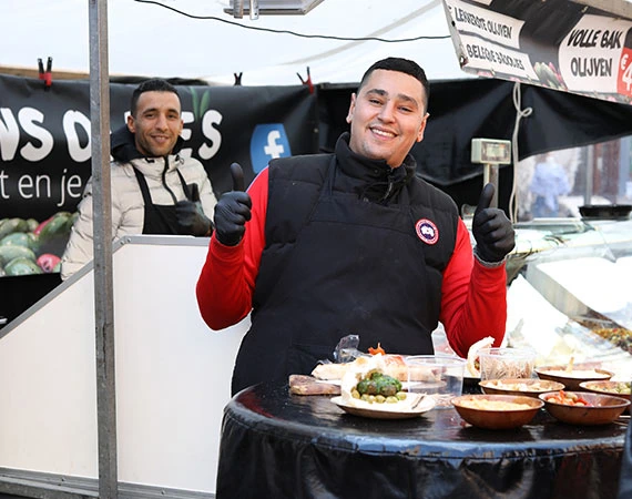 Albert Cuyp Market Chef preparing food and a happy customer for vegan travel guide to Amsterdam 2026.