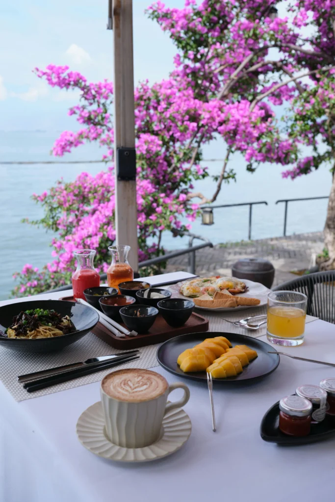 Cooked food on the table with blooming tree on the background, good for plant-based wellness for travellers.