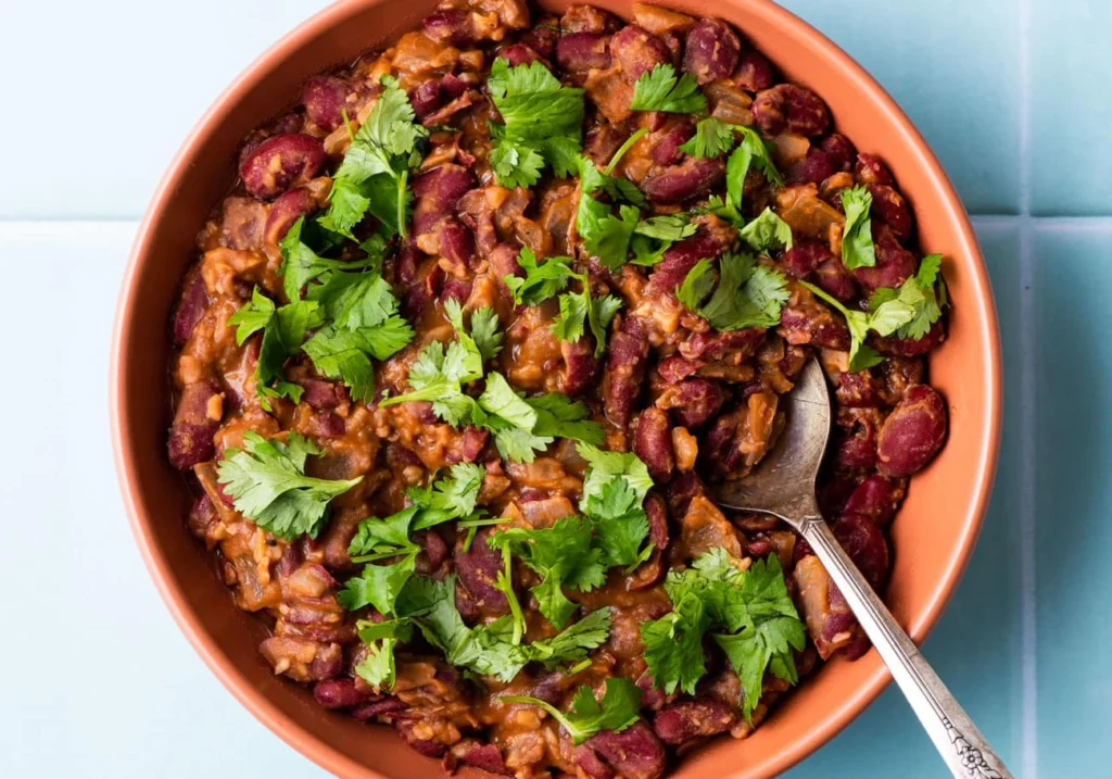 A bowl of lobio and walnut stew in a brown bowl with a spoon on top one of the meals to enjoy on your vegan travel to Tbilisi.